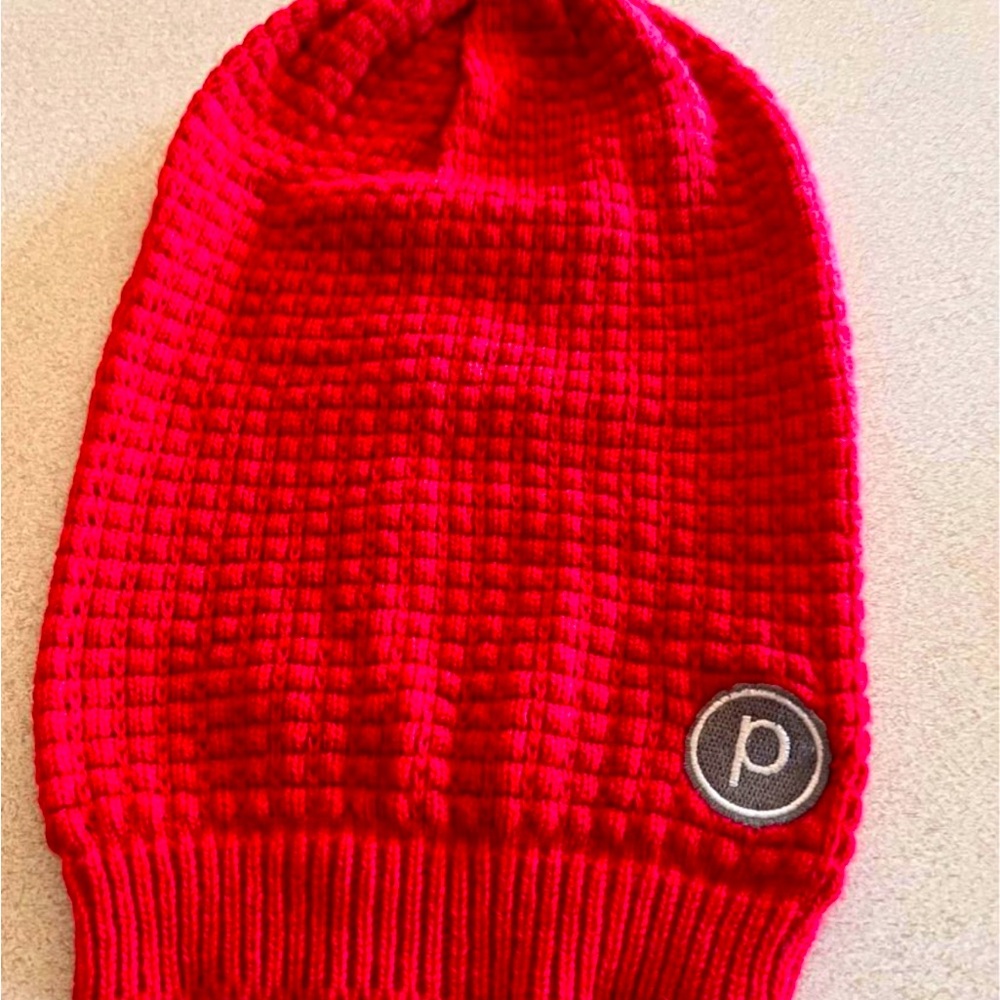 Pure Barre beanie in bright red with a small P logo